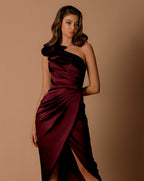 Woman wearing a burgundy one-shoulder dress against a brown background