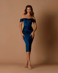 Woman wearing a blue off-shoulder dress against a brown background