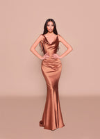 Woman wearing a bronze evening gown against a beige background