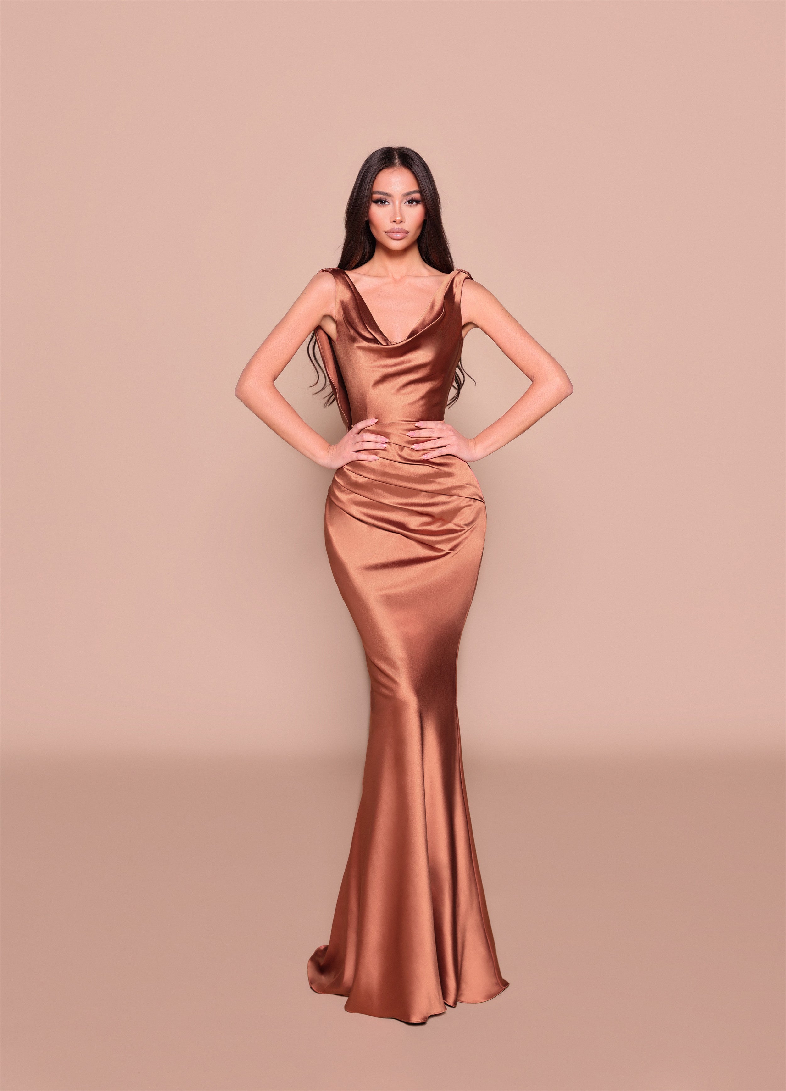 Woman wearing a bronze evening gown against a beige background