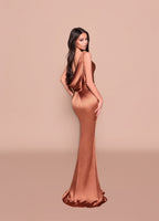 Woman wearing a bronze evening gown against a beige background