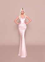 Woman wearing a pink evening gown against a beige background