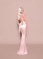 Woman wearing a pink evening gown against a beige background