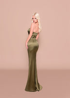 Woman wearing a strapless green evening gown against a beige background