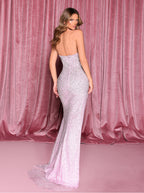 Woman in a sparkly silver evening gown against a pink curtain backdrop