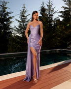 Woman in a strapless purple gown standing on a wooden deck with trees in the background