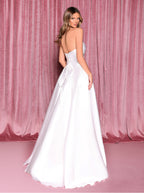 Woman in a white strapless gown against a pink curtain backdrop