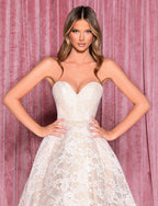 Woman wearing a white lace dress against a pink curtain background