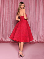 Woman wearing a red lace dress against a pink curtain background