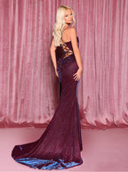Woman in a glamorous evening gown against a pink curtain backdrop