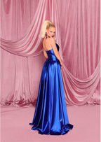 Woman in a blue evening gown against a pink draped curtain backdrop