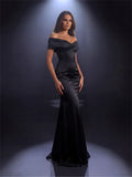 Woman wearing a black off-shoulder gown against a dark background