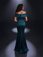 Woman wearing a teal off-shoulder gown against a dark background