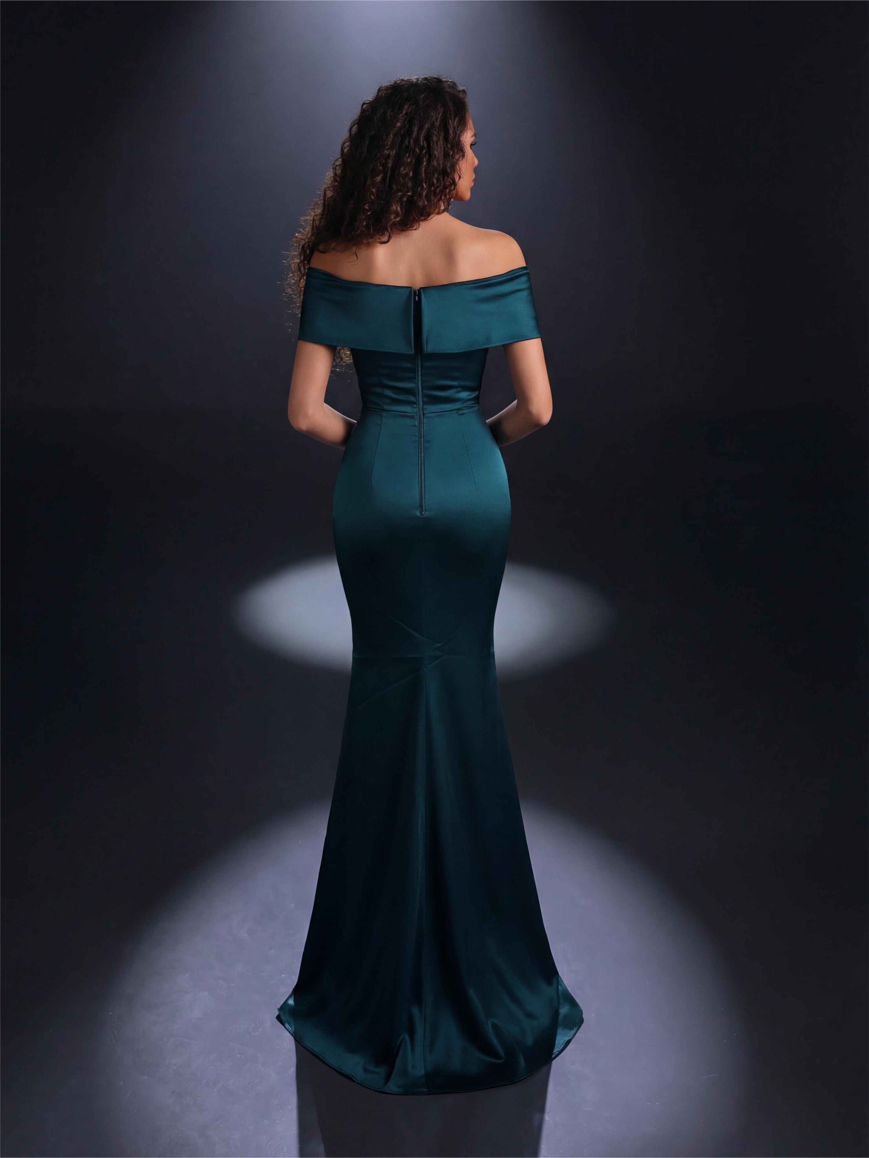 Woman wearing a teal off-shoulder gown against a dark background
