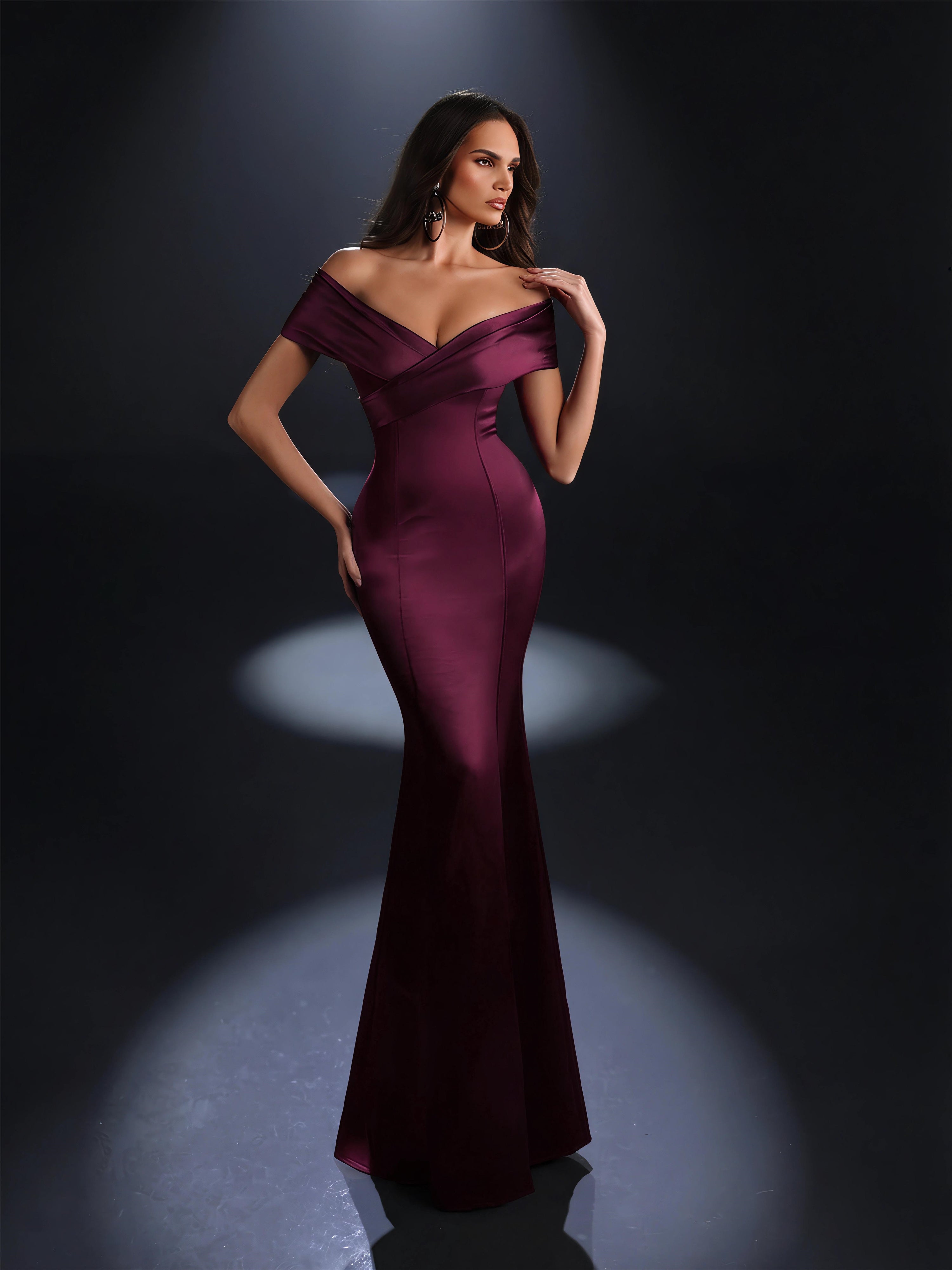 Woman wearing a burgundy off-shoulder gown against a dark background