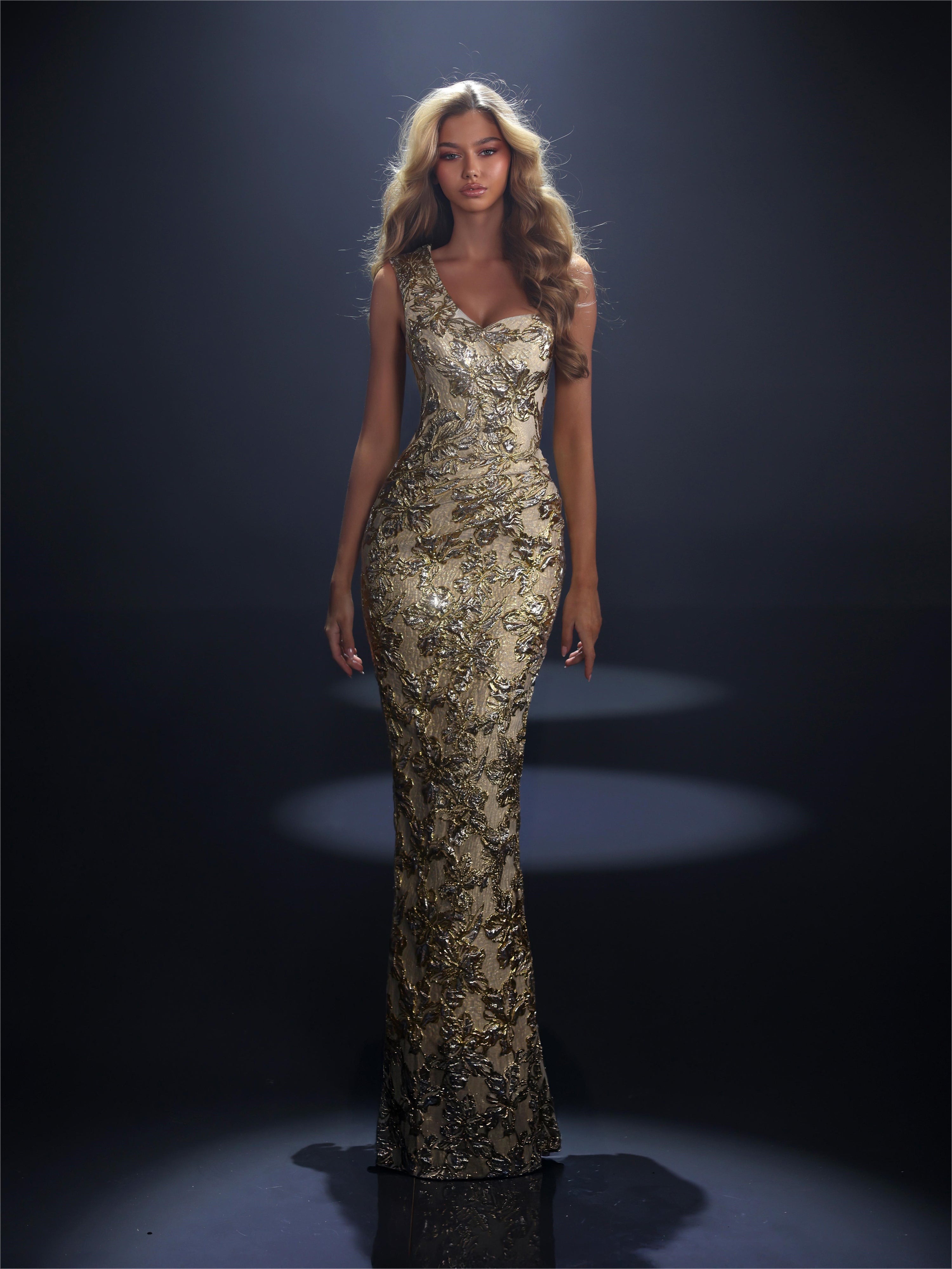 Woman wearing a gold sequin evening gown against a dark background