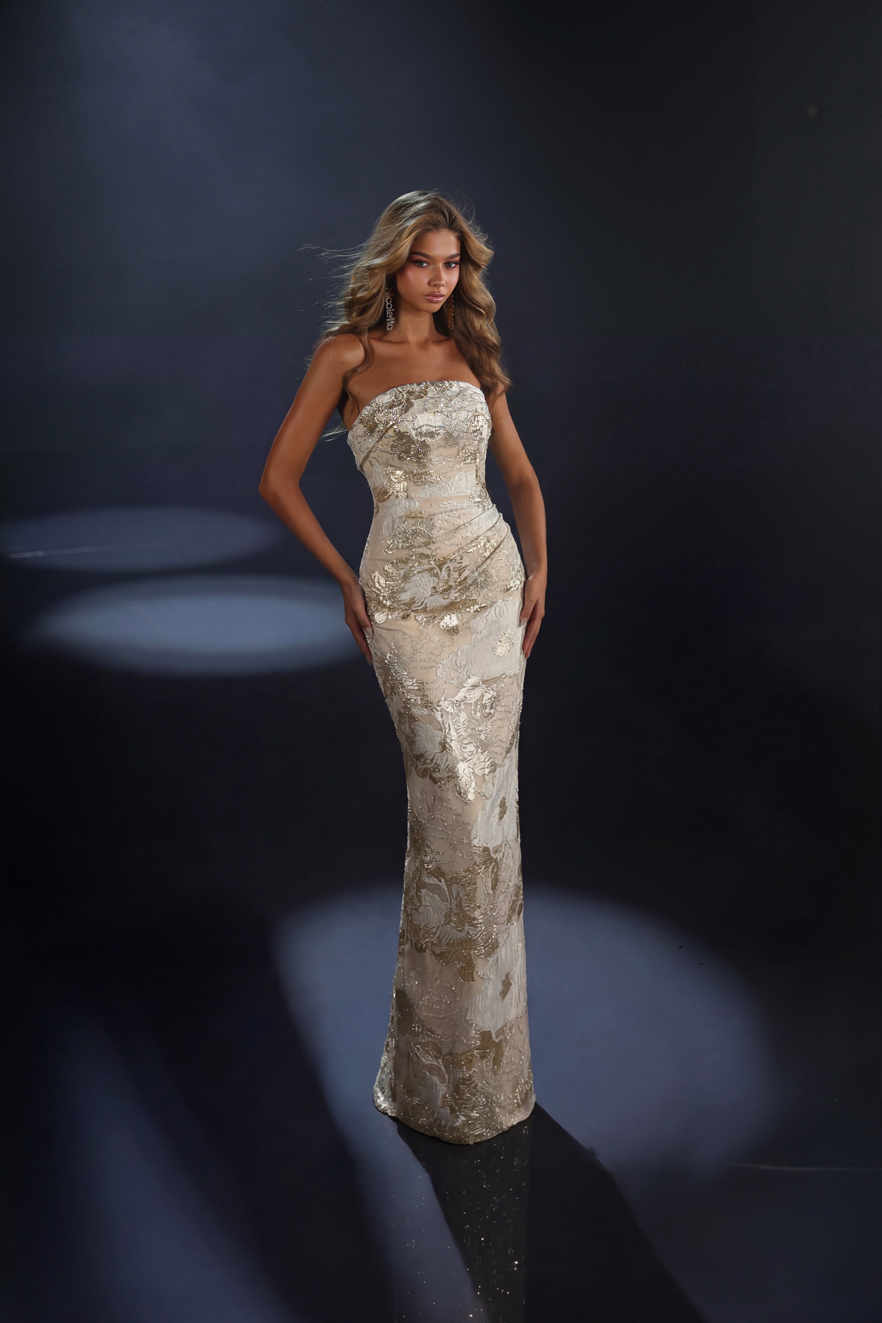 Woman in a long, elegant dress against a dark background