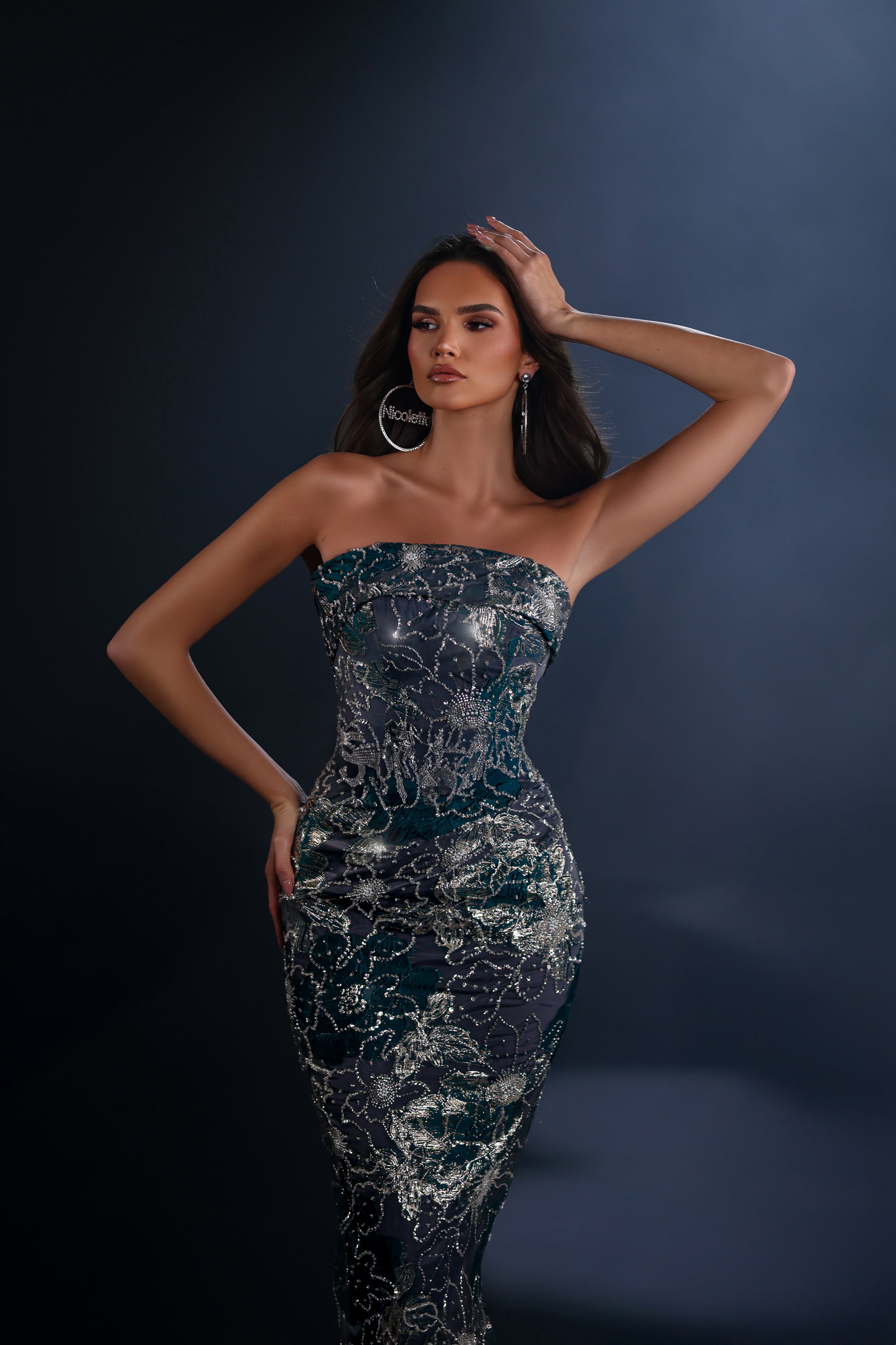 Woman wearing a strapless dress with a dark background