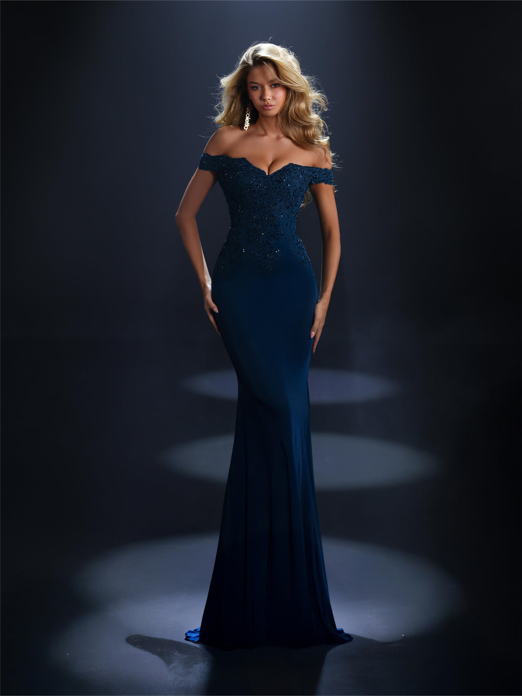 Woman wearing a blue evening gown against a dark background