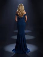 Woman in a blue evening gown standing in a spotlight against a dark background