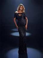 Woman wearing a black evening gown with a deep neckline against a dark background