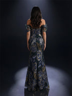 Woman wearing a floral off-shoulder gown against a dark background