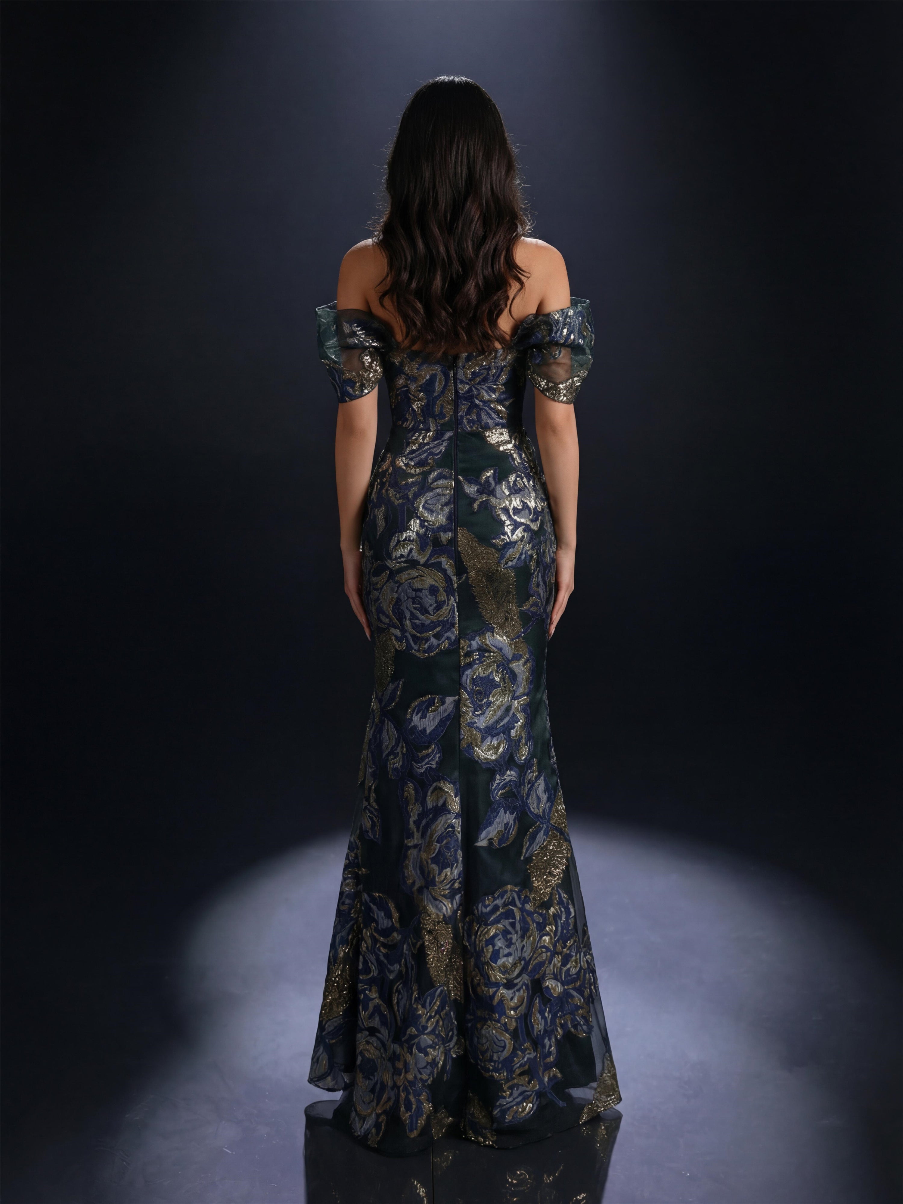 Woman wearing a floral off-shoulder gown against a dark background
