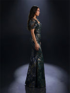 Woman in a dark green sequined evening gown against a black background