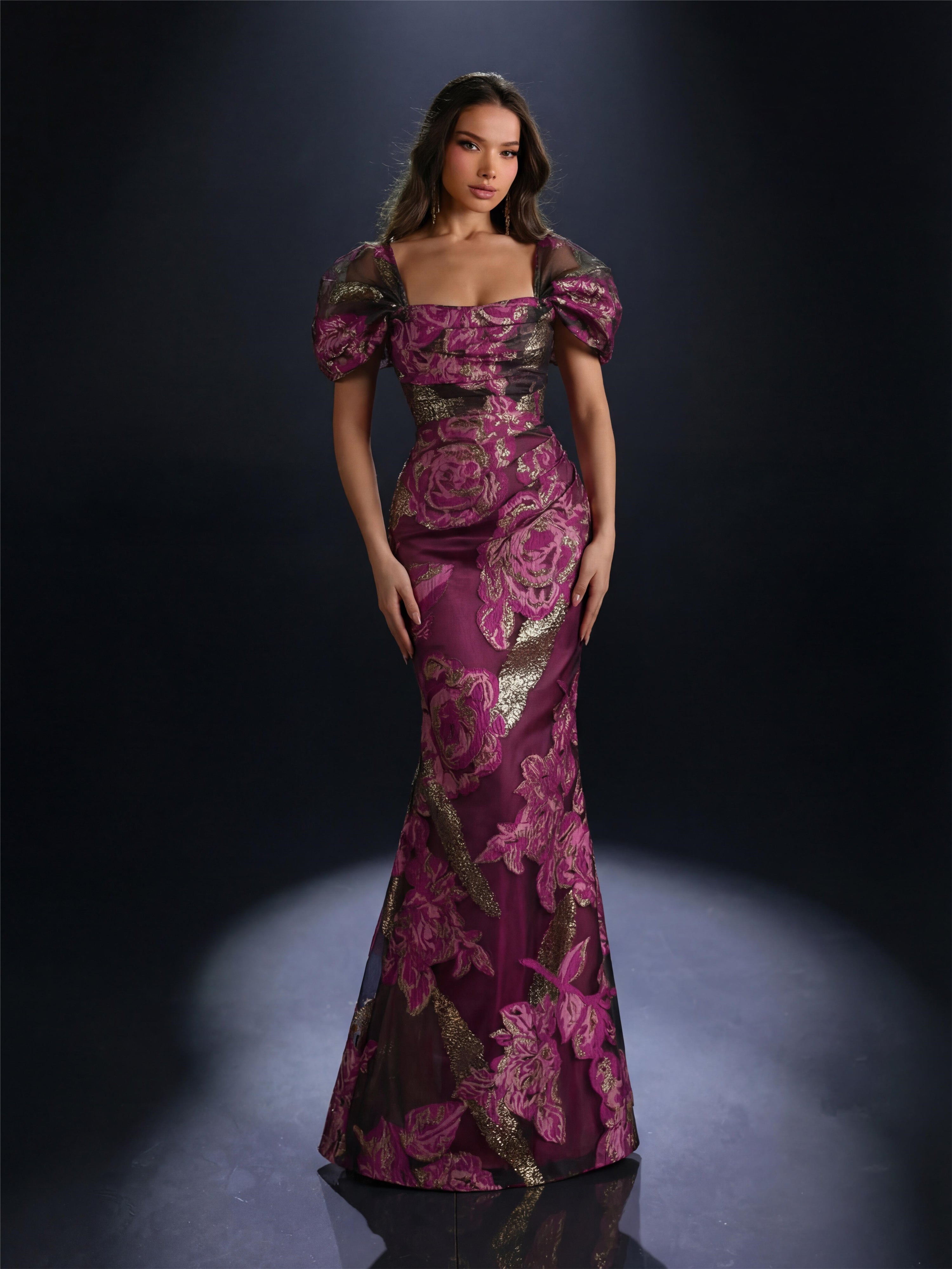 Woman wearing a purple floral evening gown against a dark background