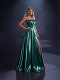 Woman wearing a green satin gown with a slit on a dark background