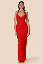 Woman wearing a red halter neck gown on a beige background