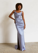 Woman wearing a light blue satin gown against a plain background