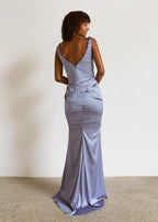 Woman wearing a light blue evening gown with a plain background