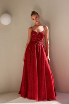 Woman wearing a red lace dress against a plain wall.