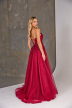 Woman wearing a red evening gown with a textured wall background