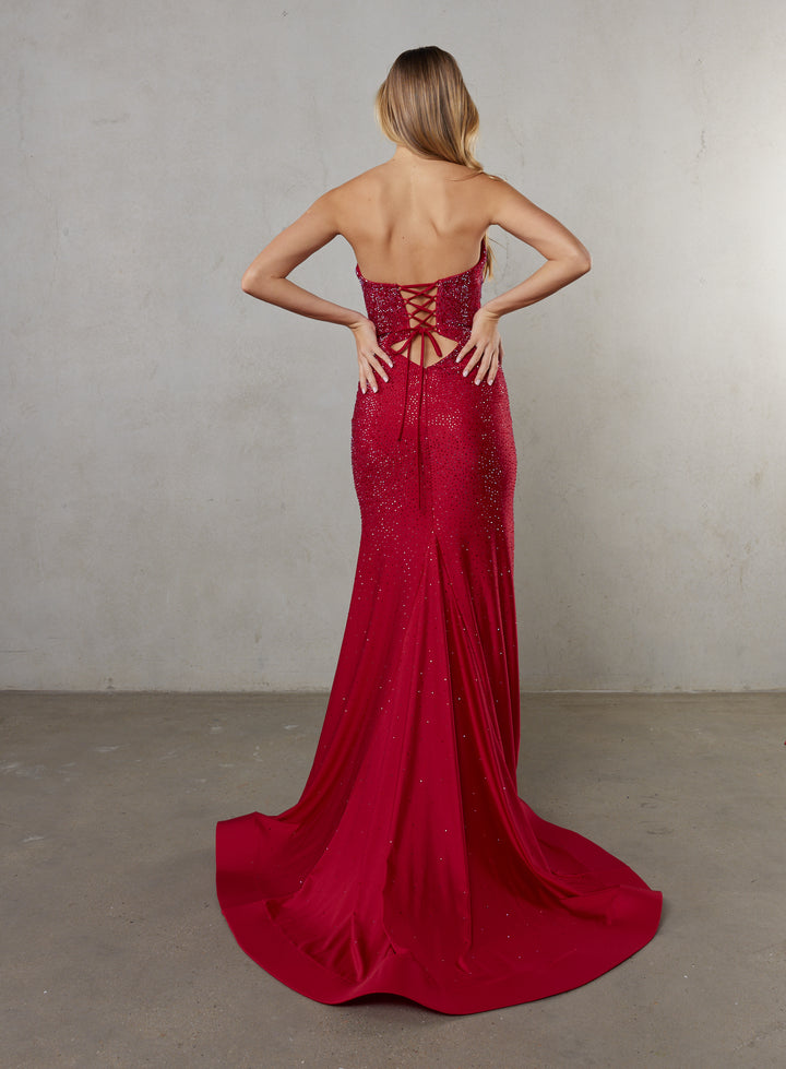 Red evening gown with a lace-up back worn by a model against a neutral background