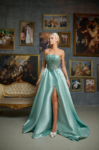 Woman in a light blue evening gown standing in a room with classical paintings on the wall.