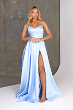 Woman wearing a light blue strapless gown with a high slit on a neutral background