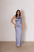 Woman wearing a light blue satin one-shoulder gown against a plain background