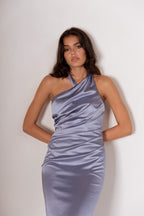 Woman wearing a light blue satin dress against a plain background