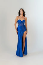 Woman wearing a blue evening gown with lace detailing on a white background