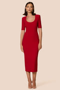 Woman wearing a red dress against a beige background