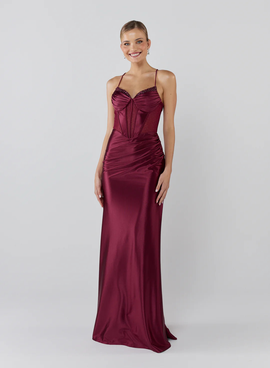 Woman wearing a burgundy evening gown on a white background