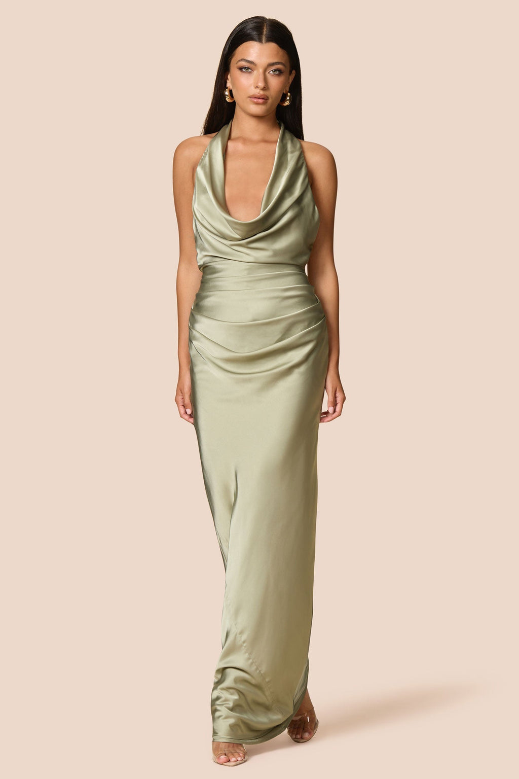 Woman wearing a green halter neck dress on a beige background
