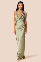 Woman wearing a green halter neck dress on a beige background