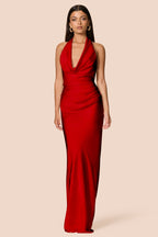 Woman wearing a red halter neck gown on a beige background