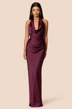 Woman wearing a burgundy evening gown on a beige background