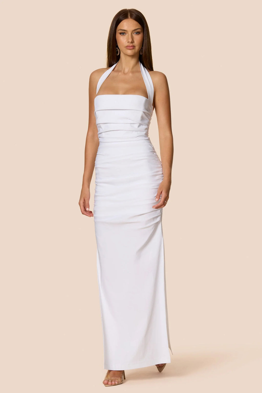 Woman wearing a white halter neck dress on a beige background