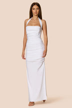 Woman wearing a white halter neck dress on a beige background