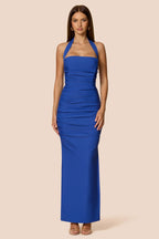 Woman wearing a blue halter neck dress on a beige background